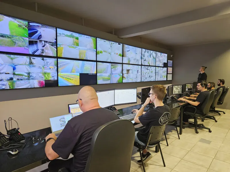 Operadores da central de monitoramento trabalhando diante do videowall